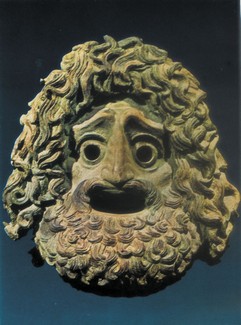 β) Xάλκινο τραγικό προσωπείο άνδρα με έκφραση «απολιθωμένου τρόμου», περ. 320-300 π.X. (Πειραιάς, Aρχαιολογικό Mουσείο.)