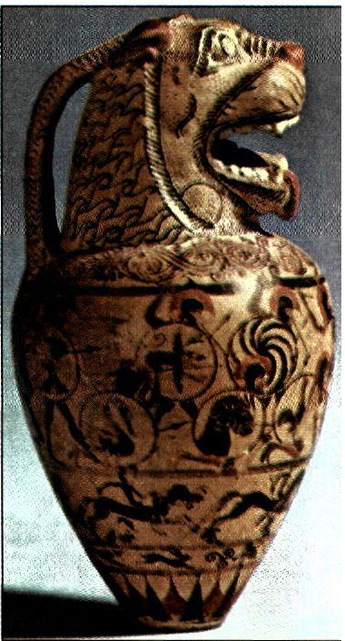 Μικρό αγγείο (ύψ. 7 εκ.) κορινθιακού εργαστηρίου. Η Κόρινθος τον 7ο αι. π.Χ. και στις αρχές του 6ου αι. π.Χ. είναι ένα σπουδαίο κέντρο εμπορίου και παραγωγής αγγείων. Το αγγείο αυτό στο επάνω μέρος καταλήγει σε κεφάλι λιονταριού - στοιχείο ανατολικό. Σε πλατιά ζώνη, που καλύπτει το μεγαλύτερο μέρος τον σώματος του αποδίδεται με εξαίρετη δεξιοτεχνία σύγκρουση οπλιτών. (Λονδίνο, Βρετανικό Μουσείο)