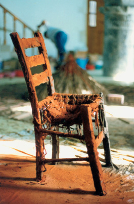 187. I. Μαυρίδης «Καρέκλα» 1998 Η παλιά καρέκλα με το επίχρισμα κόκκινου χώματος απέκτησε δραματική διάσταση και την πολυτιμότητα ενός αντικειμένου μνήμης