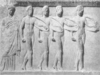 Tέσσερις άντρες χορεύουν τον πυρρίχιο χορό. Mαρμάρινη βάση αγάλματος, 330-320 π.X. (Aθήνα, Mουσείο Aκροπόλεως.)